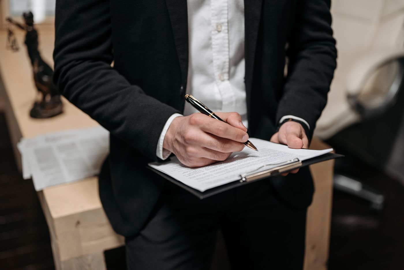 Homme en costume remplissant un document